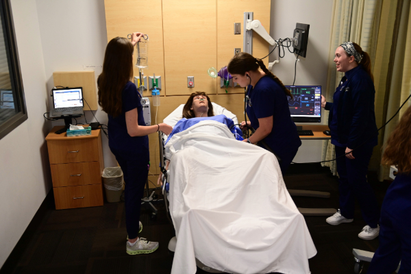 Nursing students practice their skills with a mannequin.