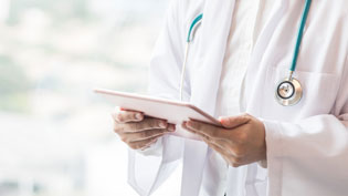 Doctor in a white coat holding a tablet.