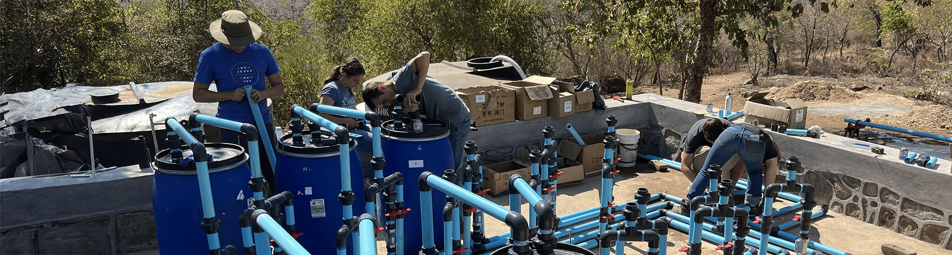 Cedarville students installing water filtration device outside in Zimbabwe.