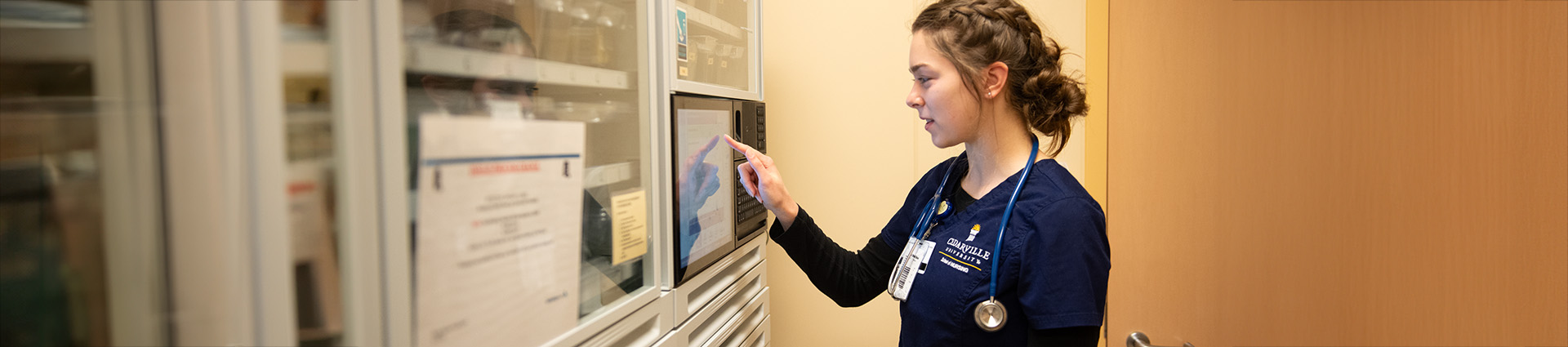 Female nursing student checking a medicine chart.