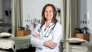 MSN FNP graduate standing in front of hospital beds