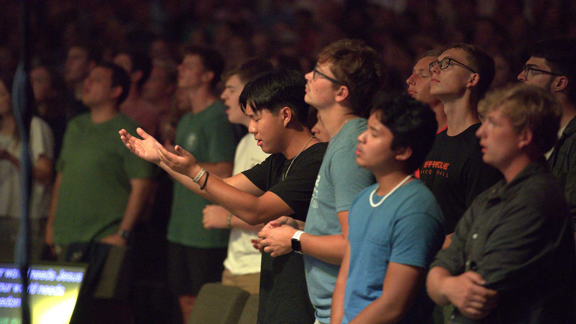 Cedarville students worshiping and raising hands during chapel.