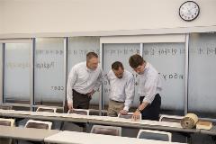 3professorslookatTorahscrollunrolledontable