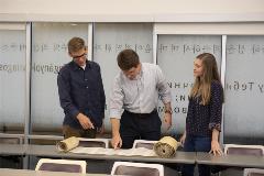 DrShepherdand2studentslookatTorahscrollandpointatcertainlinesofit