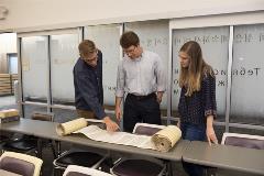 2studentswithDrShepherdlookatpartiallyopenTorahscroll