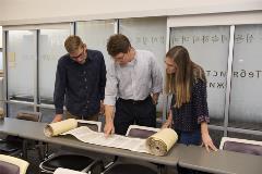 2studentswithDrShepherdlookatpartiallyopenTorahscroll