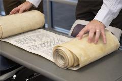 SomeoneunrollingtheTorahScrollonatable